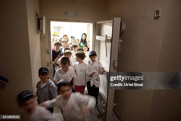 Israeli schoolchildren exit a bomb shelter during a Home Front command drill simulating a rocket hitting a school on February 14, 2013 in Ra'anana,...