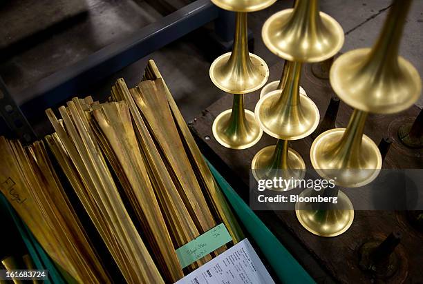 Shaped trumpet bells sit stacked next to a tub of brass tubes waiting to be shaped in the manufacturing department of the E.K Blessing Co. In...