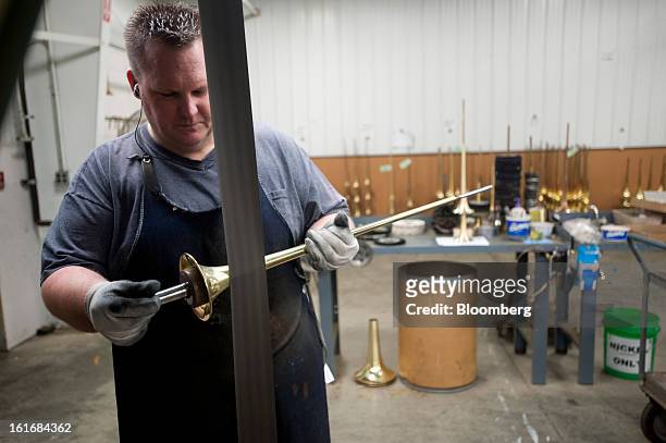 Worker uses a buffing wheel to remove any imperfections on a trumpet bell in the manufacturing department of the E.K Blessing Co. In Elkhart,...