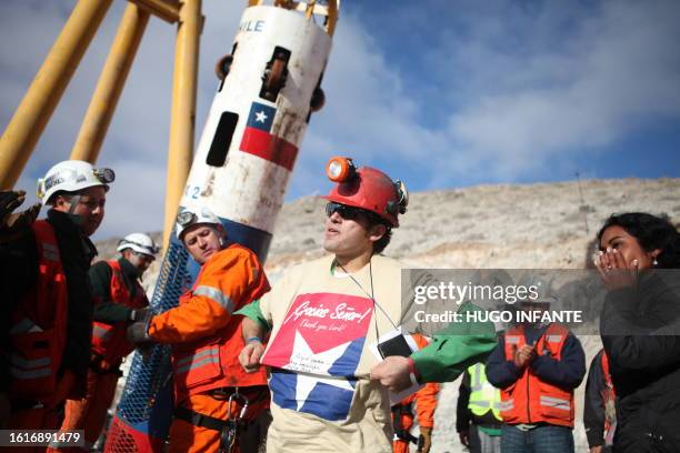 Chilean miner Alex Vega , the tenth of thirty-three miners to leave the mine, shows his t-shirt where it reads "Thanks Lord!", upon surfacing from...