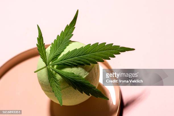 cannabis hemp marijuana leaf and bath bomb on white color background. concept of a legalization of cannabinoid products for medical treatments and beauty cosmetic products - bath bomb stock pictures, royalty-free photos & images
