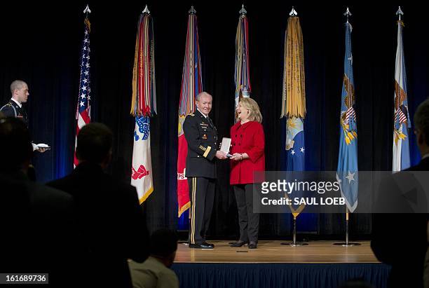 Chairman of the Joint Chiefs of Staff Martin Dempsey presents former Secretary of State Hillary Clinton with the Chairman of the Joint Chiefs of...