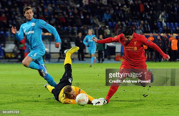 Luis Suarez of Liverpool rounds Vyacheslav Malafeev of FC Zenit St Petersburg during the UEFA Europa League round of 32 first leg match between FC...