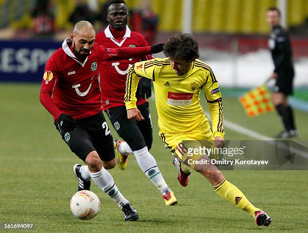 Yuri Zhirkov of FC Anji Makhachkala is challenged by Sofian Chahed of Hannover 96 during the UEFA Europa League round of 32 first leg between FC Anji...