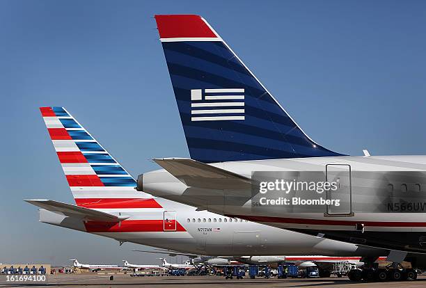 An AMR Corp.'s American Airlines airplane, left, and a US Airways Group Inc. Airplane sit parked at a gate at Dallas Fort Worth Airport in Fort...