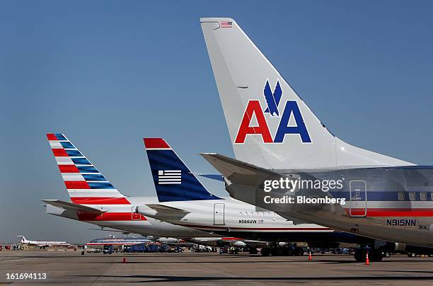 Airways Group Inc. Airplane, center, sits flanked by AMR Corp.'s American Airlines' jets at a gate at Dallas Fort Worth Airport in Fort Worth, Texas,...
