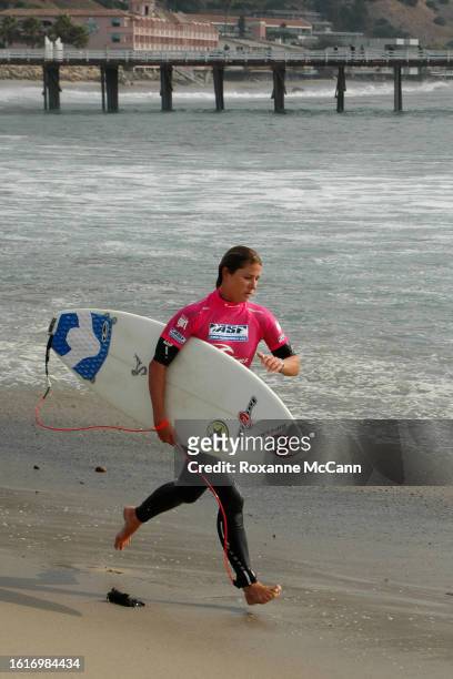 Peruvian surfer Sofia Mulanovich runs up the beach at the 2005 Rip Curl Malibu Pro Surfing Contest wearing a black wetsuit with a hot pink shirt and...