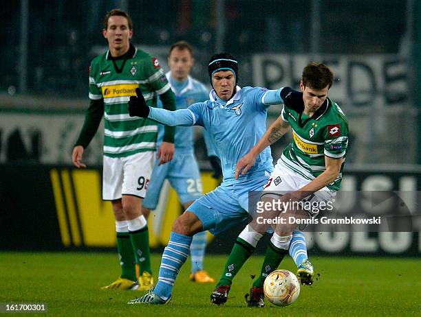 Hernanes of Lazio challenges Havard Nordtveit of Moenchengladbach during the UEFA Europa League round of 32 first leg match between VfL Borussia...