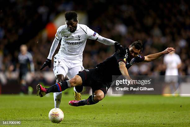Emmanuel Adebayour of Spurs is tackled by Dejan Lovren Olympique Lyonnais during the UEFA Europa League round of 32 first leg match between Tottenham...