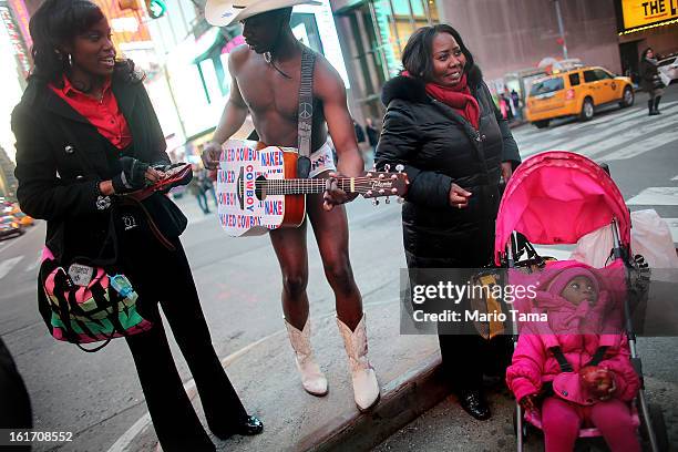 Mora Giwa stands next to performer Titus Gandy in Times Square during Valentine's Day celebrations on February 14, 2013 in New York City. People...