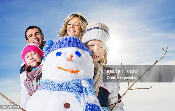 family made a snowman. - father and mother with their daughter playing in the snow stock pictures, royalty-free photos & images