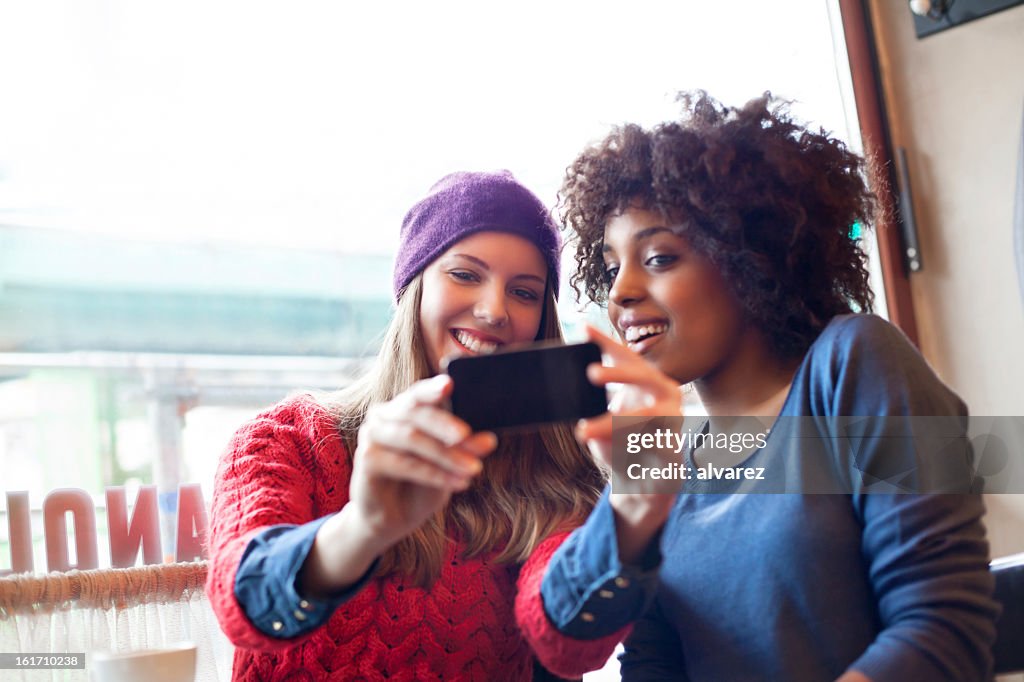 Deux jeunes filles, prendre des photos avec un smartphone