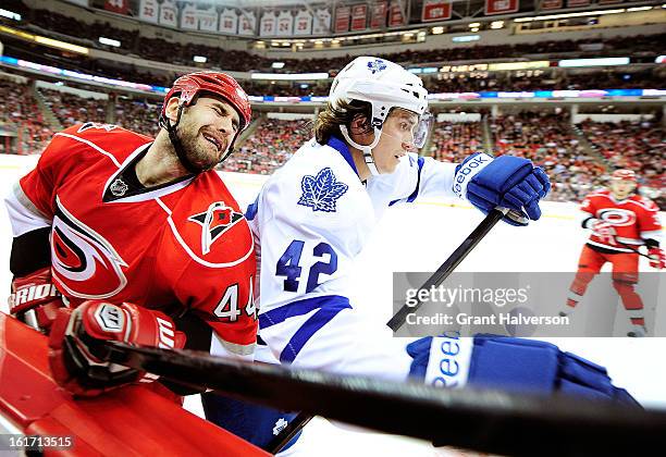 Tyler Bozak of the Toronto Maple checks Jay Harrison of the Carolina Hurricanes during play at PNC Arena on February 14, 2013 in Raleigh, North...