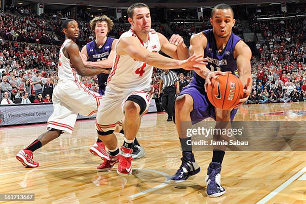 Aaron Craft of the Ohio State Buckeyes and Reggie Hearn of the Northwestern Wildcats chase down a loose ball in the first half on February 14, 2013...