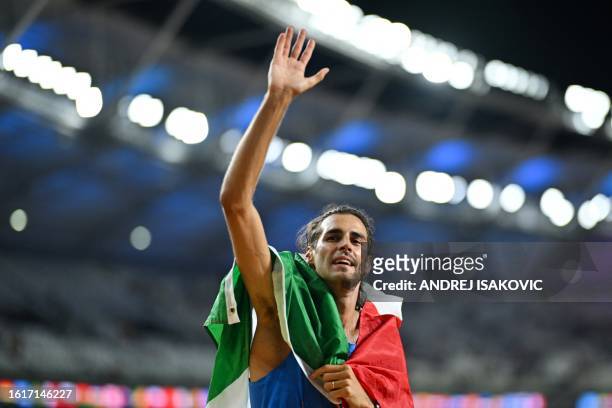 First-placed Italy's Gianmarco Tamberi celebrates after winning in the men's high jump final during the World Athletics Championships at the National...