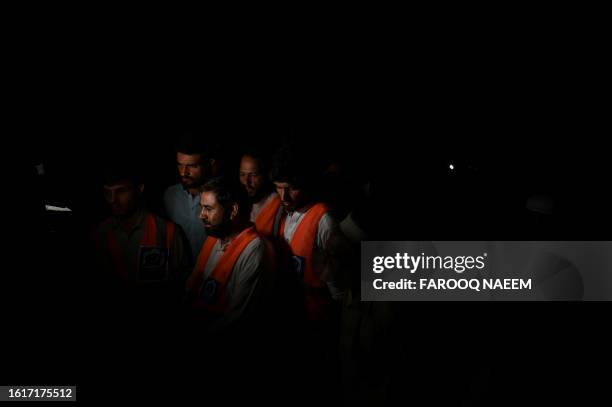 Rescuers gather at the end of the rescue operation that saved students trapped in a cable car in Pashto village, northwestern Pakistan, on late...