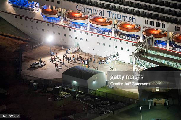 The media await the final unloading from the crippled cruise liner Carnival Triumph February 14, 2013 in Mobile, Alabama. An engine fire on February...