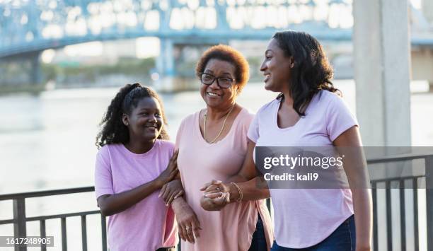 ältere afroamerikanische frau mit liebevoller familie - dreiviertel vorderansicht stock-fotos und bilder