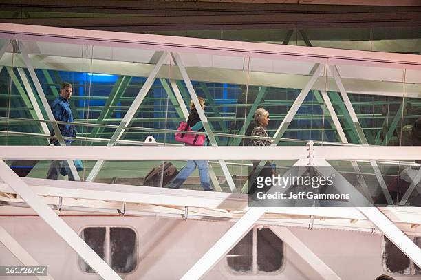Passengers walk down the terminal from the crippled cruise liner Carnival Triumph February 14, 2013 in Mobile, Alabama. An engine fire on February 10...