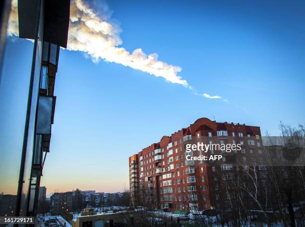 Meteorite trail is seen above a residential apartment block in the Urals city of Chelyabinsk, on February 15, 2013. A heavy meteor shower rained down...