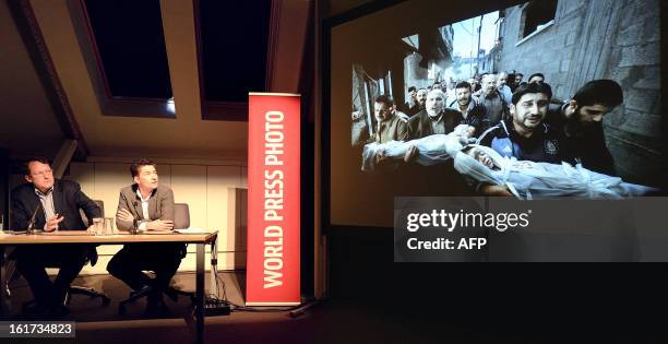 World Press Photo jury president Santiago Lyon and Managing Director of World Press Photo Michael Munneke look at the contest's winning photo during...