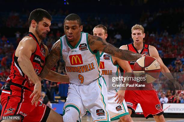 Gary Ervin of the Crocodiles looks to dribble past Kevin Lisch of the Wildcats during the round 19 NBL match between the Perth Wildcats and the...