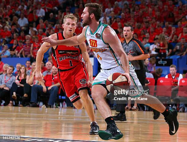 Mitch Norton of the Crocodiles works the ball up the court against Rhys Carter of the Wildcats during the round 19 NBL match between the Perth...