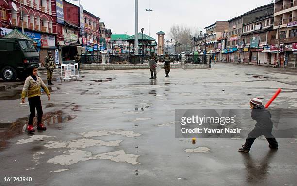 Kashmir Muslim children play cricket as Indian paramilitary soldiers patrol streets in city centre during a strict curfew on the seventh consecutive...