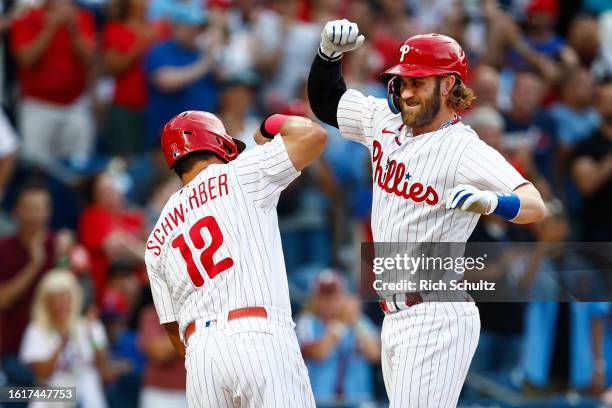 Bryce Harper of the Philadelphia Phillies is congratulated by Kyle Schwarber of the Philadelphia Phillies after hitting a two-run home run against...