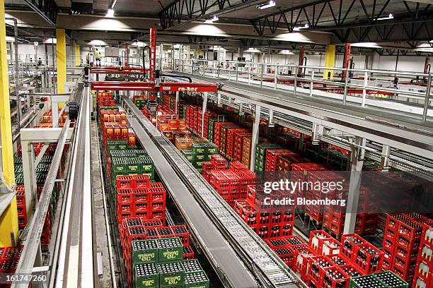 Tuborg-branded crates containing beer and soft drinks, including Coca Cola move along a conveyor belt before an automated stacking process by machine...
