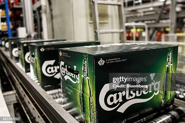 Boxes of Carlsberg bottled beer move along a conveyor belt before an automated stacking process by machine for customer orders at the Carlsberg A/S...