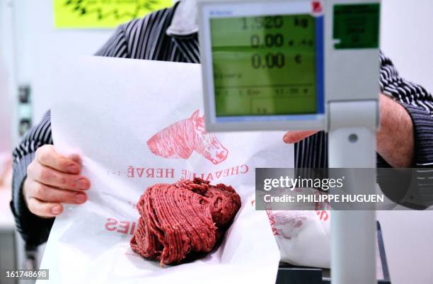 An artisan butcher works in his horsemeat butcher on February 15, 2013 in Roubaix, northern France. AFP PHOTO PHILIPPE HUGUEN