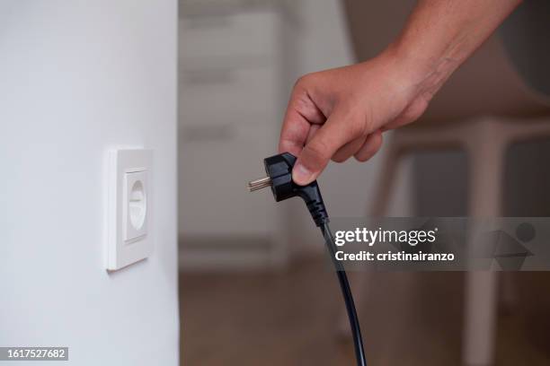 man about to plug in - enchufar fotografías e imágenes de stock