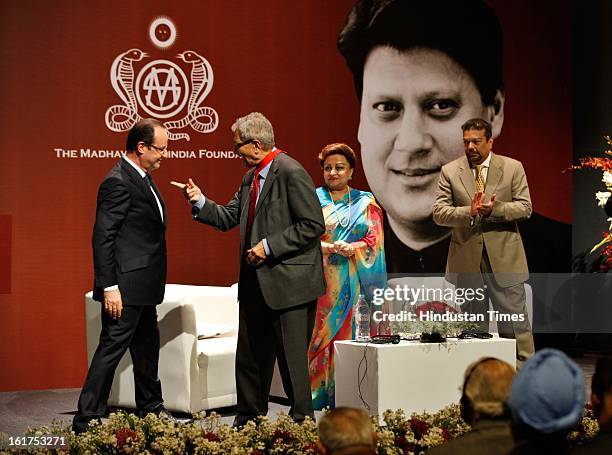 French President Francois Hollande speaks with Indian Nobel laureate Amartya Sen, as Madhavi Raje Scindia and Vir Sangvi looks on, after presenting...