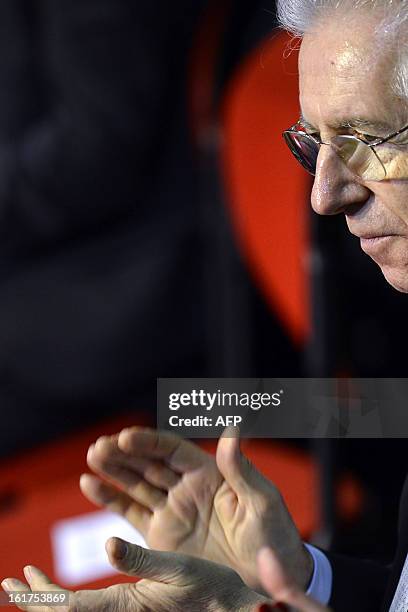 Outgoing Italy's Prime Minister Mario Monti applauds during a rally of the centrist electoral coalition 'With Monti for Italy' on February 15, 2013...