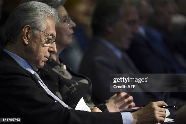 Italy's outgoing Prime Minister Mario Monti reads his notes during a rally of the centrist electoral coalition 'With Monti for Italy' on February 15,...