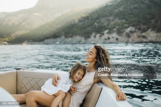 pleasant young family relaxing on a micro motorboat. - family yacht stock pictures, royalty-free photos & images