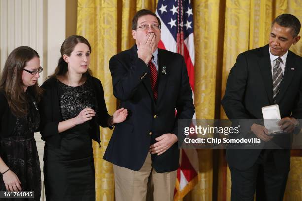 Bill Sherlach blows a kiss skyward as U.S. President Barack Obama presents him and daughters Katy Sherlach and Maura Lynn Schwartz with the 2012...