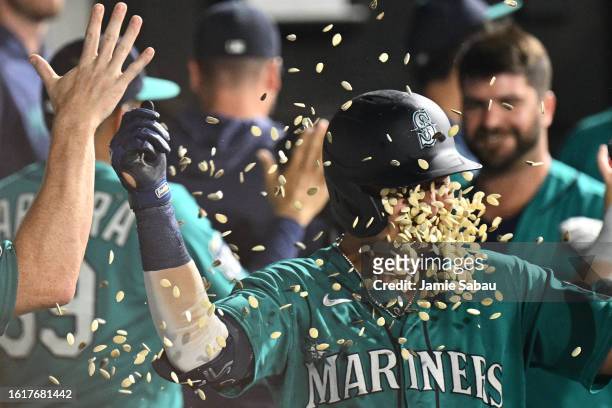 Josh Rojas of the Seattle Mariners is showered with sunflower seeds in the dugout after hitting a two-run home run in the fourth inning against the...