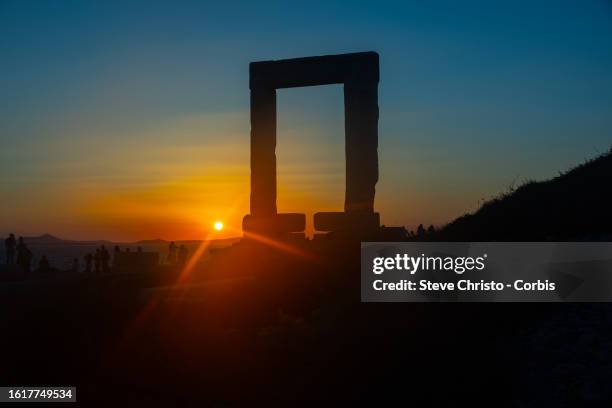 Pilgrimage of tourists at sunset to the Temple of Apollo or The Great Door is a massive marble doorway that stands proudly as the jewel of Naxos, on...