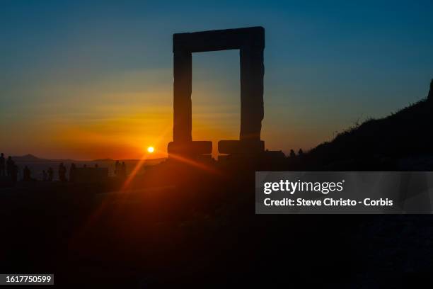 Pilgrimage of tourists at sunset to the Temple of Apollo or The Great Door is a massive marble doorway that stands proudly as the jewel of Naxos, on...