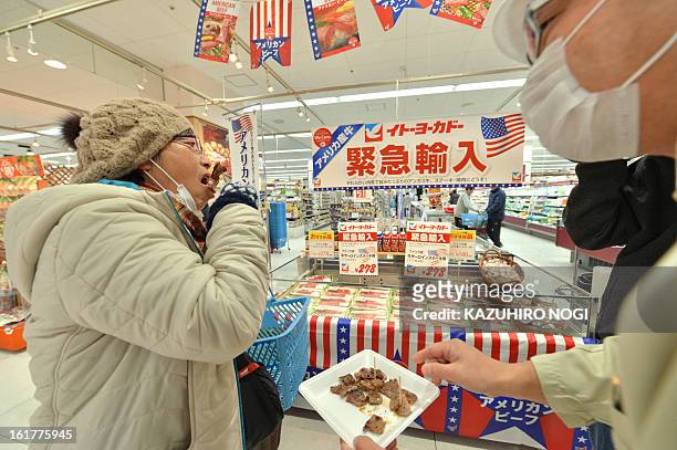 Customer tastes a sample of imported beef, under 30 months old from the US at a Ito-Yokado supermarket in Tokyo on February 16, 2013. The United...