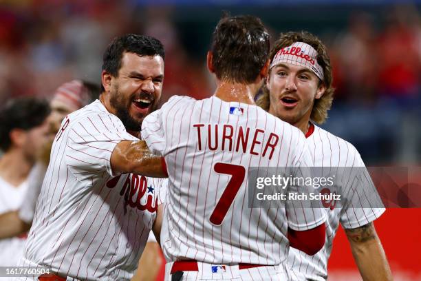 Trea Turner of the Philadelphia Phillies celebrates with Kyle Schwarber and Bryson Stott after he hit a two-run walk off single to defeat the San...