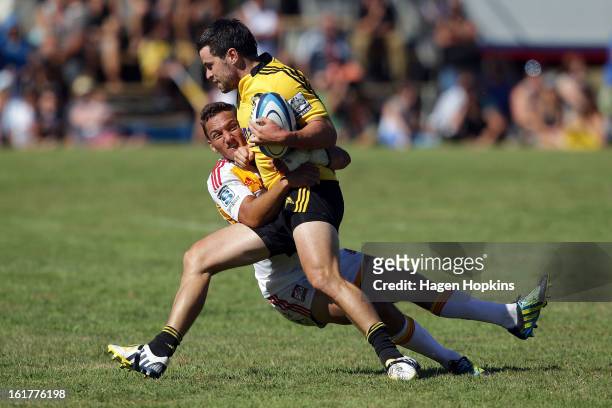 James Marshall of the Hurricanes is tackled by Aaron Cruden of the Chiefs during the Super Rugby trial match between the Hurricanes and the Chiefs at...