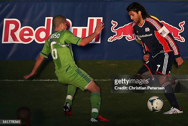 Juan Toja of the New England Revolution handles the ball guarded by Osvaldo Alonso of the Seattle Sounders during FC Tucson Desert Diamond Cup at...