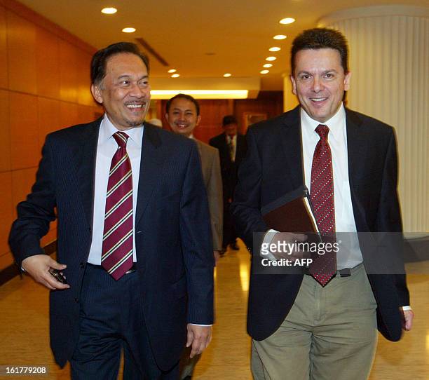 This picture taken on December 8, 2010 shows Malaysia's opposition leader Anwar Ibrahim walking with Nick Xenophon, an outspoken independent Senator...