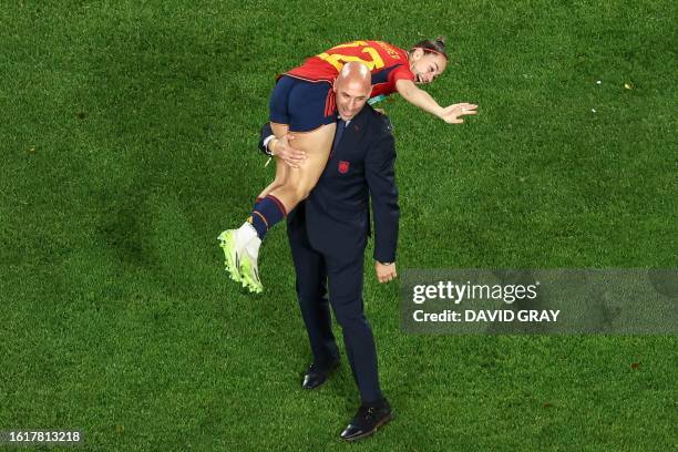 This picture taken on August 20, 2023 shows President of the Royal Spanish Football Federation Luis Rubiales carrying Spain's Athenea del Castillo...