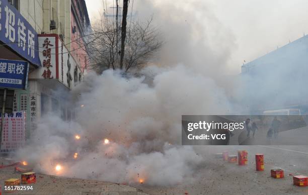 Fireworks explode for good fortune on a road on February 16, 2013 in Taiyuan, Shanxi Province of China. Local businesses in China rushed to set off...