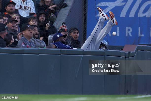 Randy Arozarena of the Tampa Bay Rays falls into the stands as he attempts to catch a ball hit by Michael Conforto of the San Francisco Giants in the...