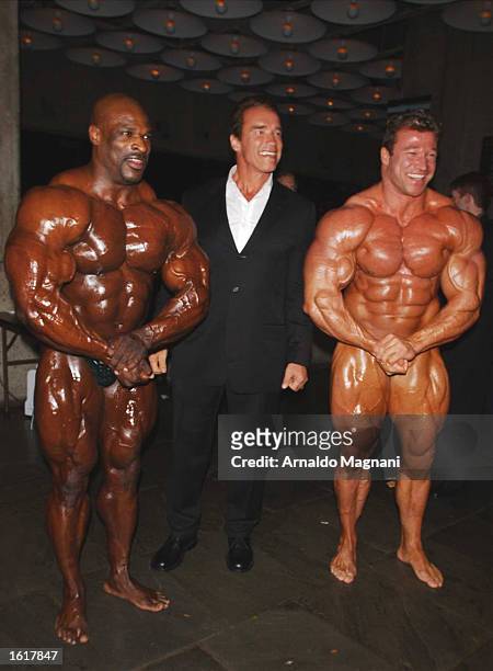Actor Arnold Schwarzenegger poses with Ronnie Coleman and Gunter Schlierkamp at the 25th anniversary celebration of the film "Pumping Iron" at Loews...